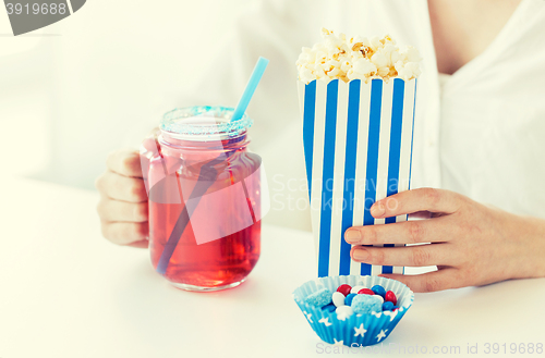 Image of woman with popcorn and drink in glass mason jar