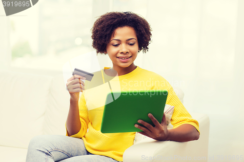 Image of happy african woman with tablet pc and credit card