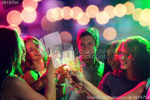 Image of smiling friends with glasses of champagne in club