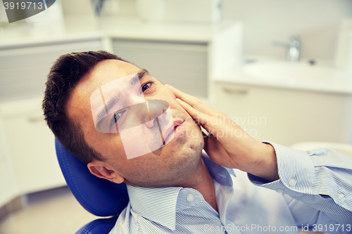 Image of man having toothache and sitting on dental chair