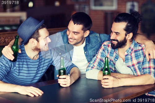 Image of happy male friends drinking beer at bar or pub