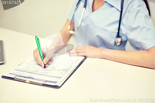 Image of close up of female doctor writing prescription