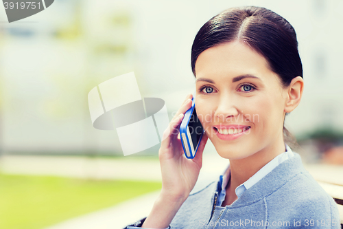 Image of young smiling businesswoman calling on smartphone