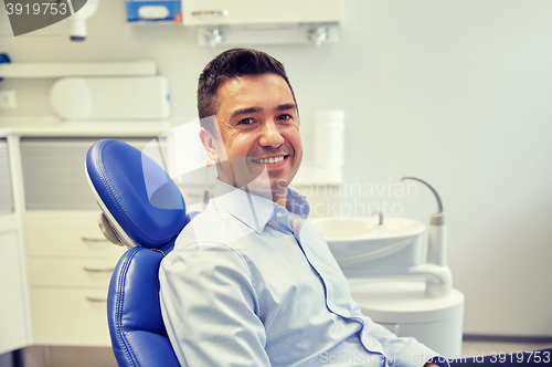 Image of happy male patient sitting on dental chair