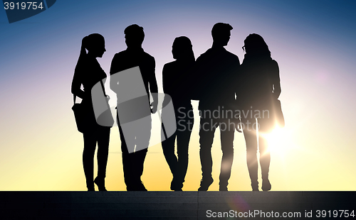 Image of silhouettes of students on stairs over sun