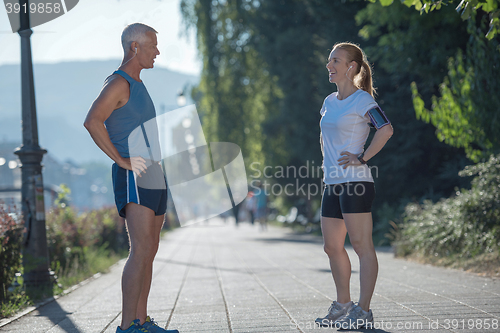 Image of jogging couple planning running route  and setting music