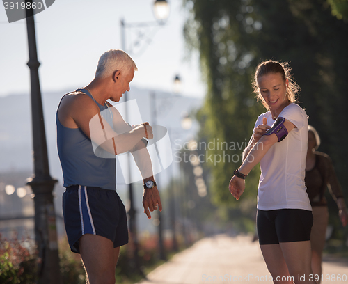 Image of jogging couple planning running route  and setting music