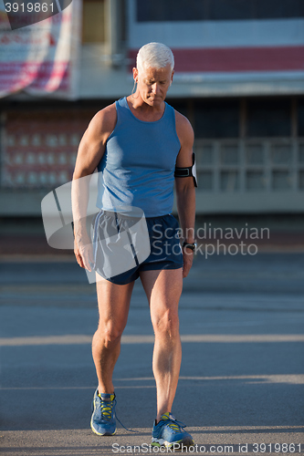 Image of portrait of handsome senior jogging man