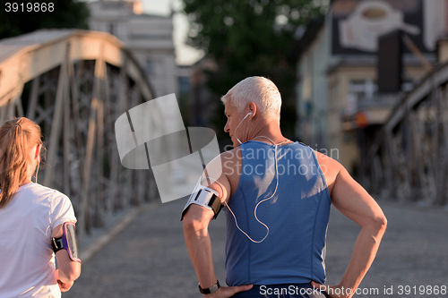 Image of jogging couple planning running route  and setting music