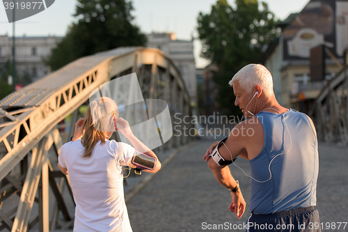 Image of jogging couple planning running route  and setting music