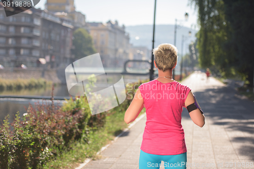 Image of jogging woman setting phone before jogging