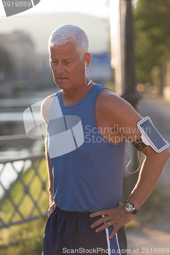 Image of portrait of handsome senior jogging man