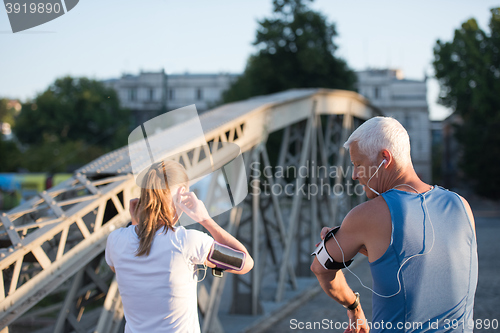 Image of jogging couple planning running route  and setting music