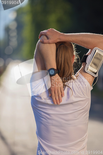 Image of blonde woman  stretching before morning jogging