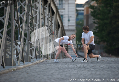 Image of couple warming up and stretching before jogging