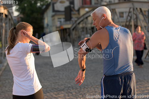 Image of jogging couple planning running route  and setting music