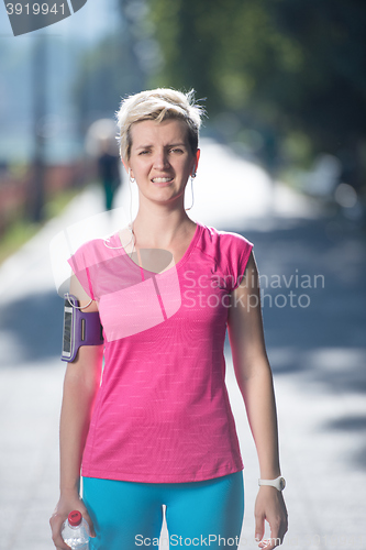 Image of sporty woman running  on sidewalk