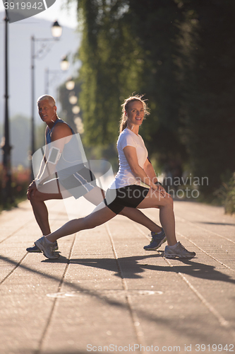 Image of couple warming up and stretching before jogging