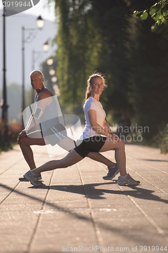 Image of couple warming up and stretching before jogging