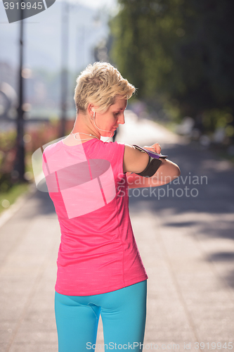 Image of jogging woman setting phone before jogging