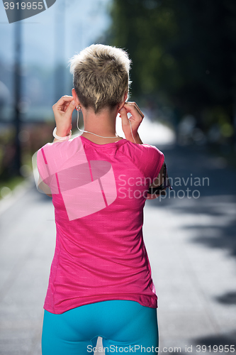 Image of jogging woman setting phone before jogging