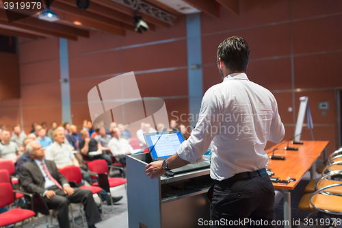 Image of Public speaker giving talk at Business Event.
