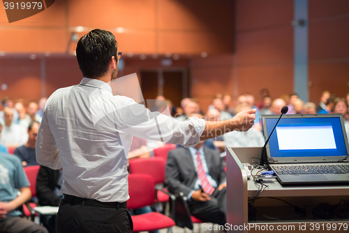 Image of Public speaker giving talk at Business Event.