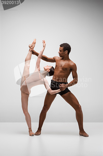 Image of Couple of ballet dancers posing over gray background