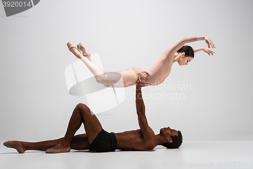 Image of Couple of ballet dancers posing over gray background