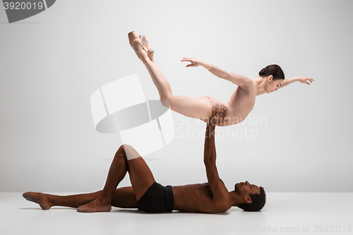 Image of Couple of ballet dancers posing over gray background