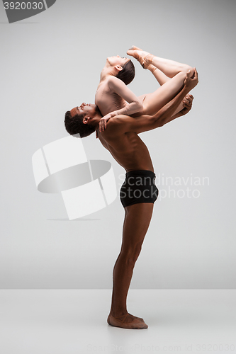 Image of Couple of ballet dancers posing over gray background