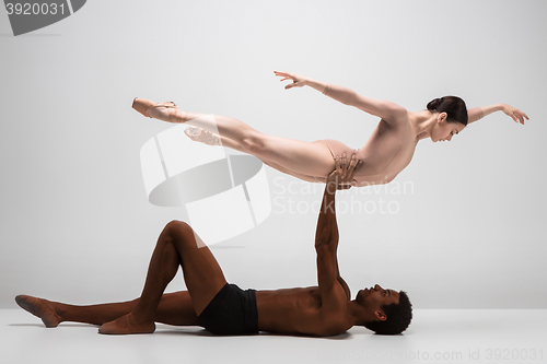 Image of Couple of ballet dancers posing over gray background