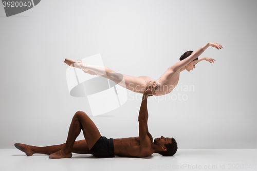 Image of Couple of ballet dancers posing over gray background