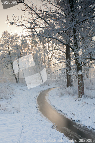 Image of Frozen river in snowy winter sunrise
