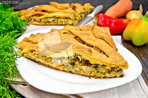 Image of Pie with cabbage and sorrel in plate on dark board