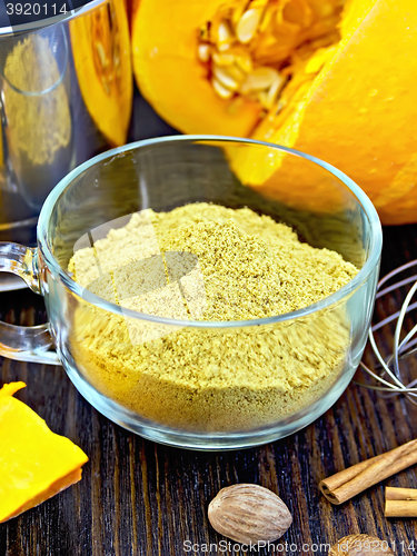 Image of Flour pumpkin in glass cup with sieve on board