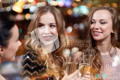 Image of happy women with champagne glasses at night club