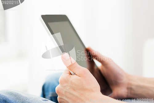 Image of close up of man working with tablet pc at home