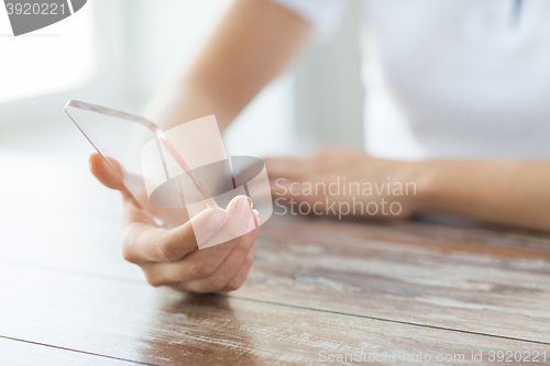 Image of close up of woman with transparent smartphone