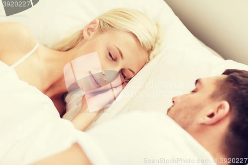 Image of happy couple sleeping in bed at home