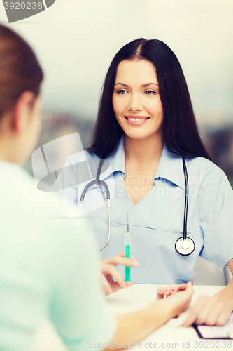 Image of smiling female doctor or nurse with syringe