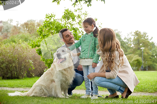 Image of happy family with labrador retriever dog in park