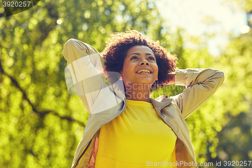 Image of happy african american young woman in summer park