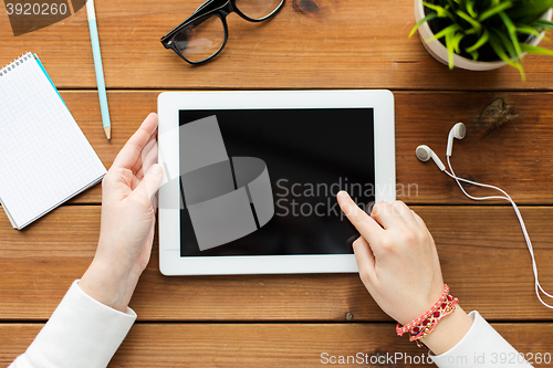 Image of close up of woman with tablet pc on wooden table