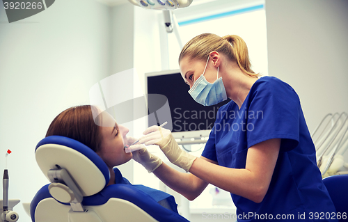 Image of female dentist checking patient girl teeth