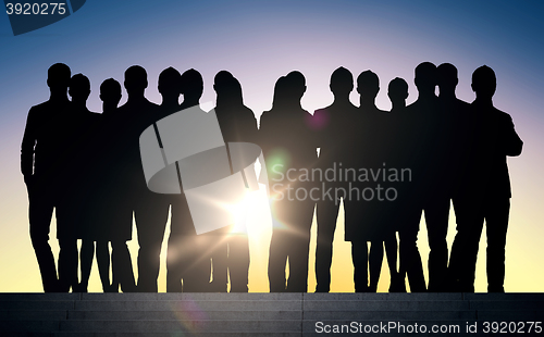 Image of business people silhouettes on stairs over sun