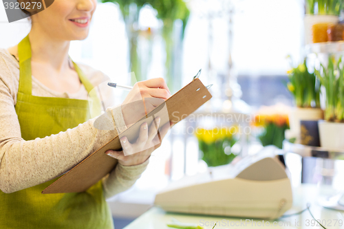 Image of close up of woman with clipboard at flower shop