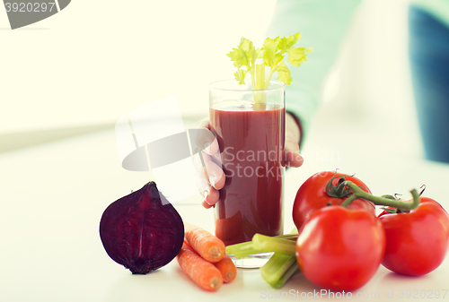 Image of close up of woman hands with juice and vegetables