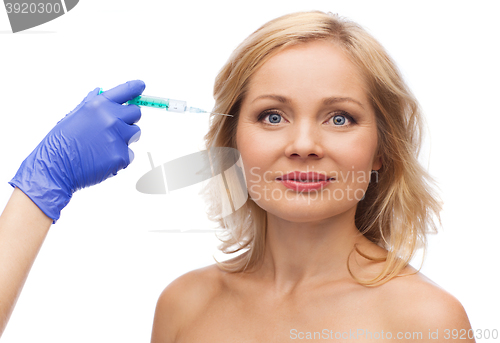 Image of happy woman face and beautician hand with syringe