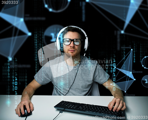 Image of man in headset hacking computer or programming